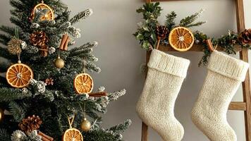 Organic cotton and wool Christmas stockings on a wooden ladder, next to a minimalist tree with dried oranges and cinnamon sticks, creating a natural holiday vibe. Christmas stockings, New Year video