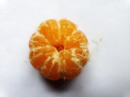 A peeled orange on a white surface photo