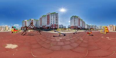 360 hdri panorama on sports or childrens playground in middle of residential complex among skyscrapers buildings with outdoor exercise equipment gym in equirectangular projection. landscaping concept photo
