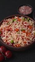 Boiled rice with vegetables, salt and spices on a dark concrete background video