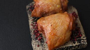 Chicken thighs fried with salt, spices and herbs on a dark concrete background video