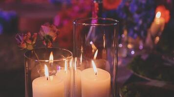 Beautiful candle scene with warm bokeh and white flowers for peaceful ambiance. An elegant candle scene with delicate white flowers and a soft, calming background. video