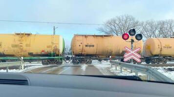 siauliai, Lituânia - 19 novembro, 2024 - carga trem passeio em estrada de ferro velozes passar carros em pé de trilhos Pare placa dentro frio inverno dia dentro báltico país lithuania.eu importar exportação bens conceito video