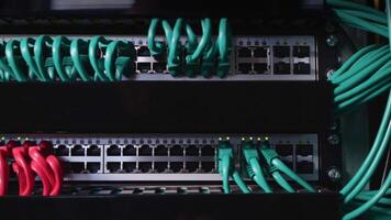 Neat and tidy patched network cables, RJ45, connected to the switches and routers mounted on the rack in data centre, networking video