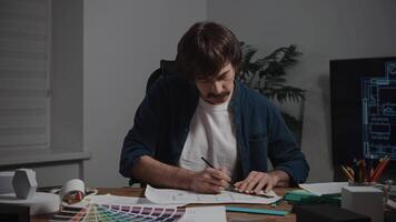 The architect designer works with drawings and samples of materials. A man at a workplace in a design studio, planning the premises. video