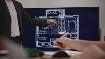 An unrecognizable woman makes a presentation of an architectural project in a design studio. House layout on the big screen video