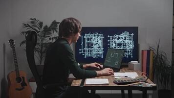 Young design engineer working on laptop on house project. Architect designer in studio video
