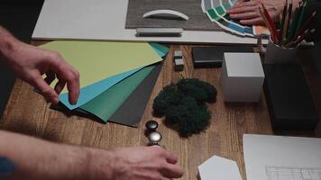 Design and architecture studio. Close-up, male and female hands of interior designers working with samples of materials and color palettes. Working on an apartment project video