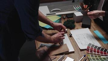 Design and architecture studio. Close-up, male and female hands of interior designers working with samples of materials and color palettes. Working on an apartment project video