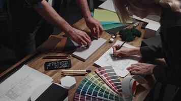 Design and architecture studio. Close-up, male and female hands of interior designers working with samples of materials and color palettes. Working on an apartment project video