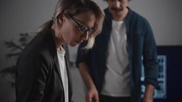 An architectural bureau. Colleagues, a man and a woman, are working on creating an interior design. The designers have laid out various textures, palettes, and material samples on the table video