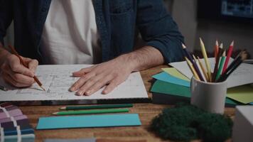 Unrecognizable male architect working with blueprint. The designer makes notes in the plan of the room. Working with architecture in a design office video