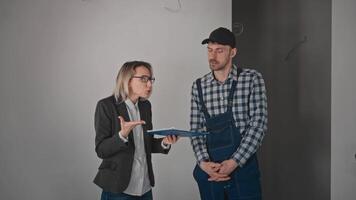 Conflict at a construction site. A woman is a customer, arguing with a builder contractor. The client is not satisfied with the construction work video