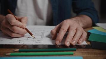 Close-up. Men's hands draw the plan of the interior. Work on a design project in a design studio. The architect selects the color and textures for the interior video