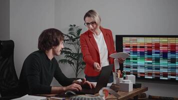 Design and architecture studio. A man and a woman are designers working with samples of materials and color palettes. Working on an apartment project. Laptop in frame video