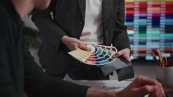 Unrecognizable interior designers select materials and color schemes for a modern apartment project. Teamwork in an architectural studio. video
