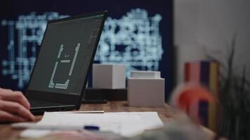 The shows male hands working with a laptop. An architect is drawing a room project using CAD software. An unidentified male engineer is working in an architectural studio video