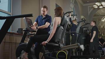 Sports rehabilitation of a patient in a specialized gym. A male physiotherapist monitors the performance of rehabilitation exercises. video
