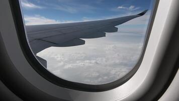 Looking out the airplane window, the plane flying above the clouds video