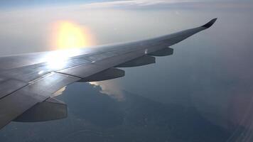 Looking out the airplane window, seeing the clouds and coastline below video