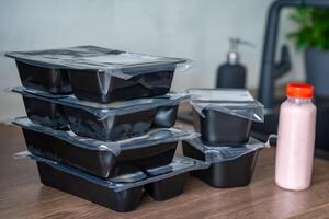 Black boxes with healthy diet plan for weight loss, delivery of daily ready meal menu. Food ordered with mobile phone app. Balanced portion with dish. Pre-cooking. High quality photo