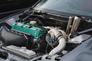 Close-up view of modified car engine, vibrant green valve cover, turbocharger, and intricate piping Ideal for automotive enthusiasts and performance vehicle projects photo