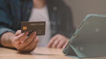 Person holds credit card in front of an electronic device, symbolizing ease and convenience of digital payments and evolving landscape of financial transactions photo