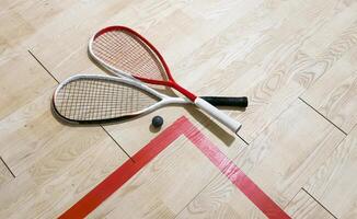 Squash rackets and ball on court floor, top view photo
