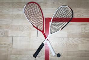 Sports, above and racket on squash court for competition, challenge and training center. Exercise, interior and empty room with top view of wooden floor of gymnasium for games, fitness club and gear photo
