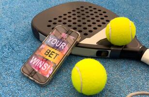 paddel racket and smartphone with bet background photo