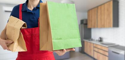 box with fast food being carried by delivery man in uniform for one of clients photo