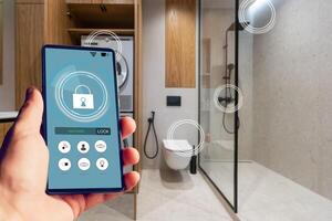 Young woman holding smart phone with launched security application at home. Concept of controlling and managing home security from a mobile device photo