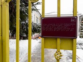 Sign in braille text with information about building in front of entrance to adjacent territory photo