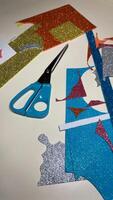 Vertical photo of table with cut pieces from sheets of multi colored foamiran
