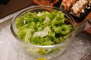 Salad and rolls in a glass bowl on the counter of a restaurant photo