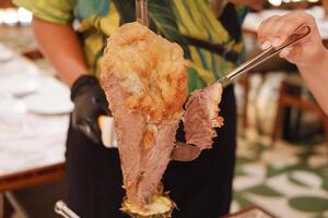 Close up of a man holding a piece of meat knuckle photo