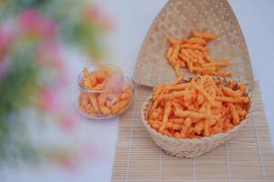 Crispy Corn Puffs in rattan on bamboo mat. Selective focus. photo