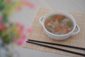 A bowl of fresh soup on a table photo