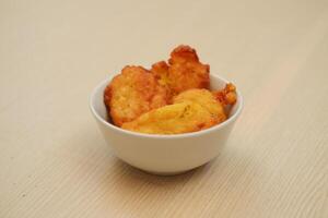 Corn croquettes in a bowl on a wooden table photo
