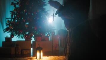 Man Prays In Silhouette In Front Of Christmas Tree At Night For Religious Peace photo