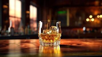 A glass of whiskey sitting on a bar counter photo