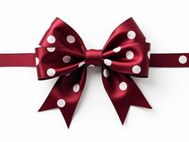 Dark red satin ribbon bow with white polka dots and long tails on a white background. Isolated decorative element for gift wrapping and design projects photo