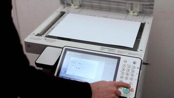 An office worker scans a sheet of A3 paper on a scanner video