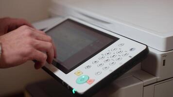 An office worker makes print settings for a printer on a touch screen video