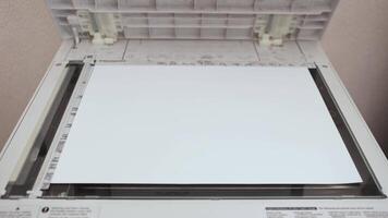 An office worker scans a sheet of A3 paper on a scanner video