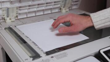 An office worker scans a sheet of A4 paper on a scanner video