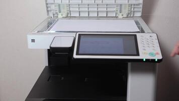 An office worker scans a sheet of A3 paper on a scanner video