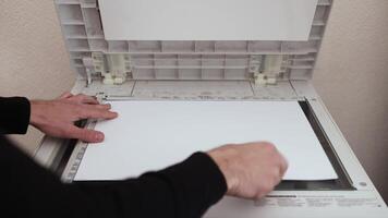 An office worker scans a sheet of A3 paper on a scanner video