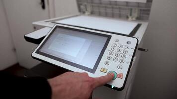 An office worker scans a sheet of A3 paper on a scanner video