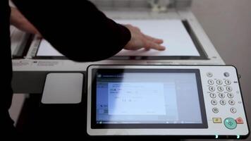 An office worker scans a sheet of A3 paper on a scanner video